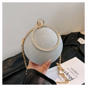 Close-up of silver glitter spherical evening bag with diamond-studded gold handle
