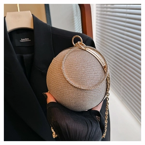Detail of champagne gold sphere evening bag with rhinestone handle and metal chain