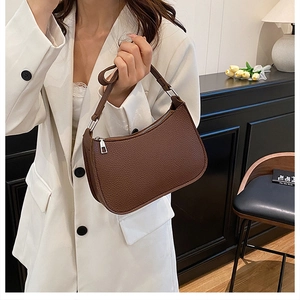 Detail showing high-quality lychee pattern brown leather texture and silver hardware zipper