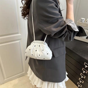 White ruffled crossbody bag with black floral print and metal clasp closure