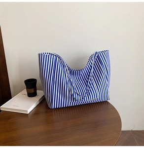 Close-up of blue and white striped canvas tote bag with functional front pocket