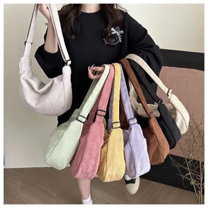 Selection of colorful corduroy crescent bags showing texture and adjustable straps