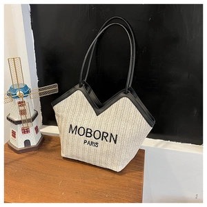 Détail du tissage en chevrons et des finitions en cuir noir sur ce sac cabas chic