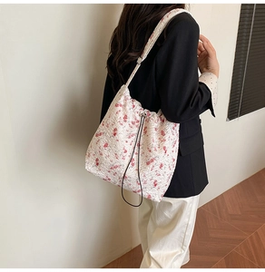 Detail view of floral fabric bucket bag showing drawstring closure and pleated texture