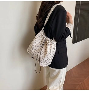 Macro shot of floral pattern fabric and black drawstring detail on casual bucket bag