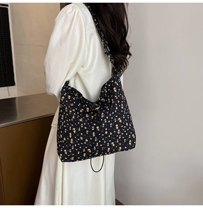 Detail of floral print canvas tote bag featuring yellow flower pattern and drawstring closure