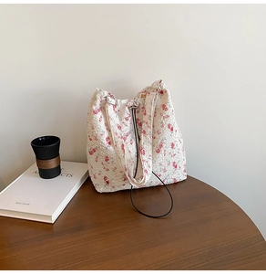 Close-up of a white floral tote bag with bumpy bubble fabric on a wooden table