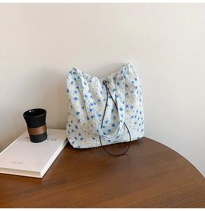 Close-up of seersucker tote bag texture with blue floral print and drawstring detail