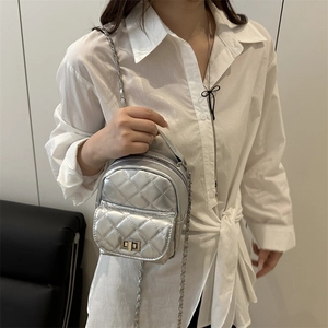 Silver quilted mini backpack featuring chain straps and metallic rhombus pattern