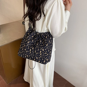Floral print shoulder bag with black drawstring closure and yellow flower pattern