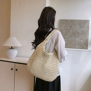 Handwoven straw tote bag with wide shoulder straps for summer beach vacations