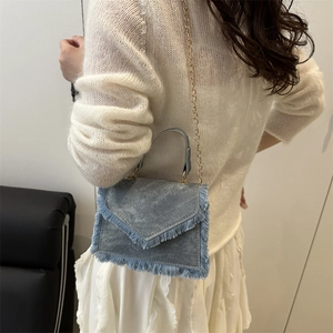 Mini sac à bandoulière en denim bleu avec détails de franges et chaîne dorée