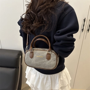 Taupe canvas bowling handbag with brown leather trim and crossbody strap for women