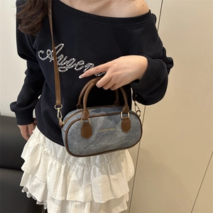 Chic cylinder denim shoulder bag in blue and brown contrast with removable strap