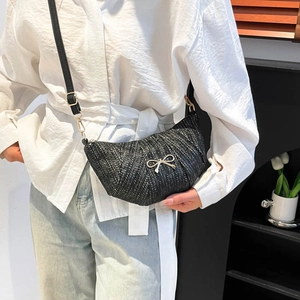 Minimalist black woven crescent bag with gold butterfly accent and adjustable strap