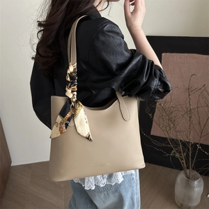 Minimalist beige soft leather tote bag with elegant floral scarf detail for daily commute