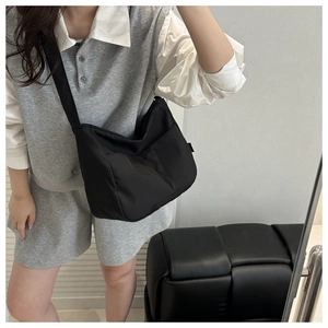 Nahaufnahme einer minimalistischen schwarzen Nylon-Umhängetasche mit verstellbarem Schultergurt