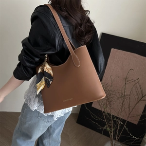 Brown vintage faux leather tote bag with white stitching and printed scarf decoration