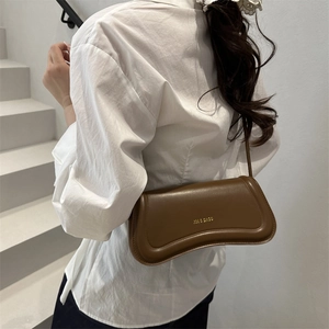 Brown leather shoulder bag with sleek irregular shape and metal logo lettering
