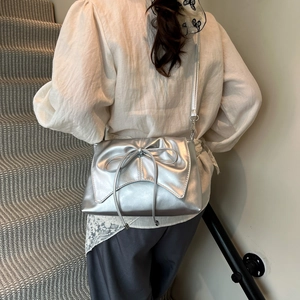 Silver ballet-style crossbody bag with metallic bow detail and pleated texture for women