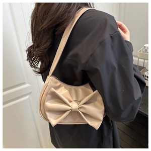 Close-up of the large bow detail on this beige synthetic leather shoulder underarm bag