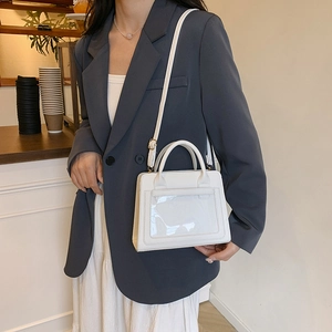 Minimalist white crossbody bag with round handles and transparent front pocket