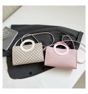 Close-up of stylish retro crossbody bags with monogram pattern and round top handles