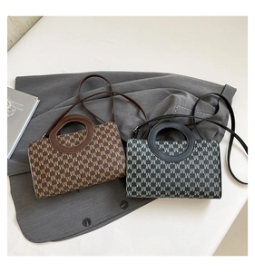 Close-up of vintage logo print handbags with leather handles and slim straps