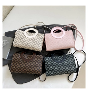 Top view of four vintage crossbody bags with circular handles and M-letter monogram patterns