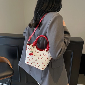 Vintage style white bucket bag with cherry print and red adjustable shoulder strap