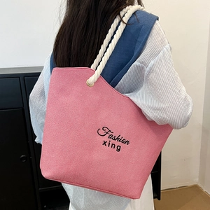 Pink canvas tote bag with thick rope straps and fashion lettering for summer travel