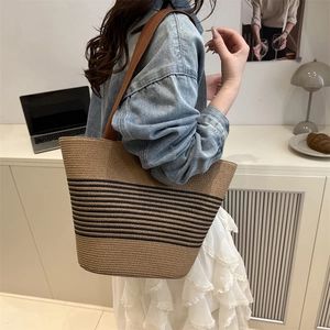 Minimalist striped straw tote bag with brown shoulder straps for beach and daily travel