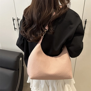 Pink diagonal textured hobo bag with a minimalist half-moon shape and golden hooks