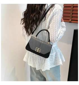 Detail showing vintage small square bag with gold BB logo and contrast textures