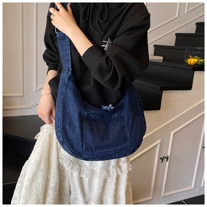 Détail du sac hobo en jean bleu foncé avec grande capacité et poche à bords effilés