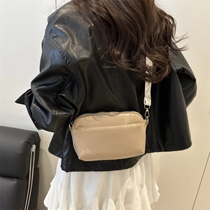 Minimalist beige crossbody camera bag with geometric wide strap for casual daily use