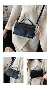 Detail of black PU leather shoulder bag with gold engraving and pearl heart charm