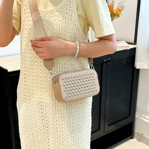 Beige rectangular crossbody bag with silver rivet studs and wide woven shoulder strap