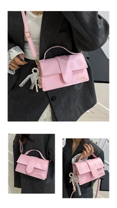 Detail of light pink shoulder bag with pearl tassel and lace bow on matte PU leather