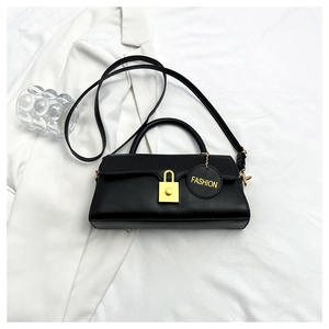 Close-up of black retro shoulder bag featuring a gold metal lock and FASHION leather tag