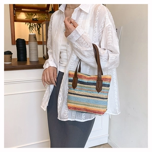 Detail of colorful striped straw woven bag with premium leather handles for summer beach vacations