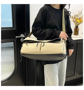 Detail of multi-functional travel bag with dual pockets and wide olive shoulder strap