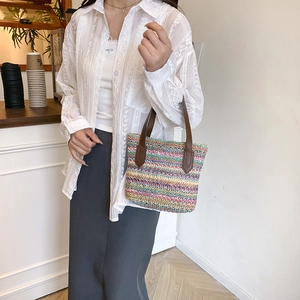 Colorful rainbow straw tote bag with brown leather handles for summer beach vacations
