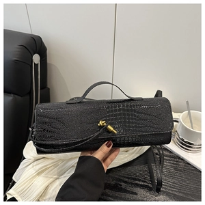 Close-up of elegant black crocodile pattern handbag with a golden twist-lock buckle detail