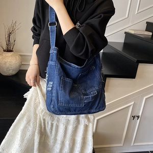 Vintage blue washed denim tote bag with cargo pockets and adjustable shoulder strap for women