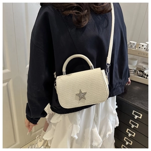 Chic cream-colored quilted handbag with star rhinestone detail shown in use