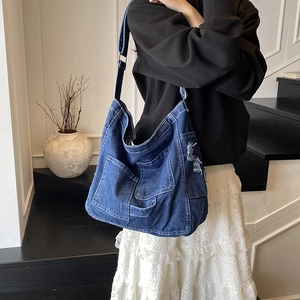 Retro washed denim tote bag with multiple pockets and distressed frayed edge details
