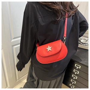 Detail of red semicircular crossbody bag with silver star ornament and leather strap