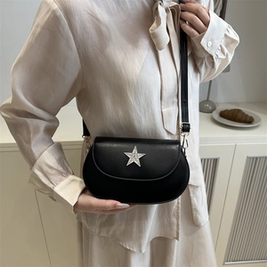 Minimalist black leather crossbody bag for women with sparkling star emblem and strap