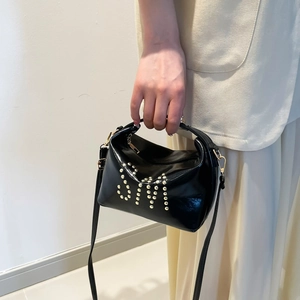 Elegante borsa a tracolla in pelle verniciata nera con borchie dorate e spallina